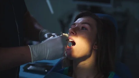 Dental procedure. Dentist using spray into patient's mouth Stock Footage 76874555