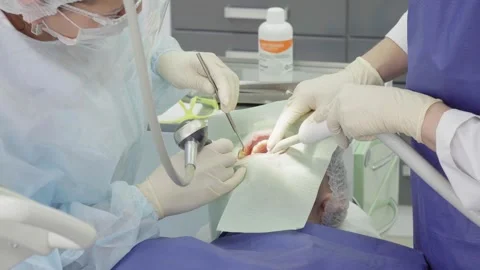 Dental procedure with medical professionals using tools in modern clinic setting Stock Footage 310687682