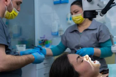 A Dental Procedure in Progress with Two Practitioners: One Focused on Patient Stock Photos