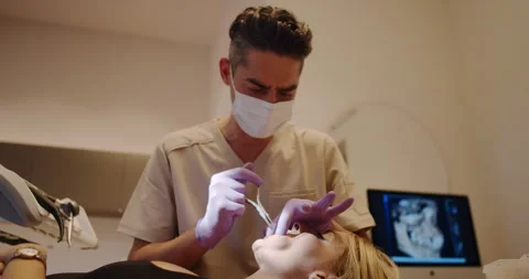 A Dental Professional Skillfully Performing a Procedure on a Patient in a Modern Stock Footage 318280850