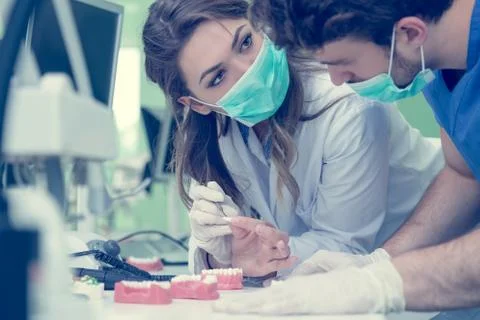 Dental students while working on the denture, false teeth. Stock Photos