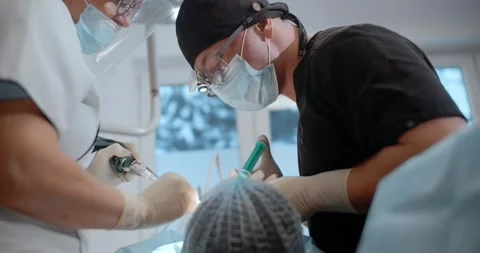 The dental surgeon does the surgery with assistant in stomatological clinic Stock Footage 265867199