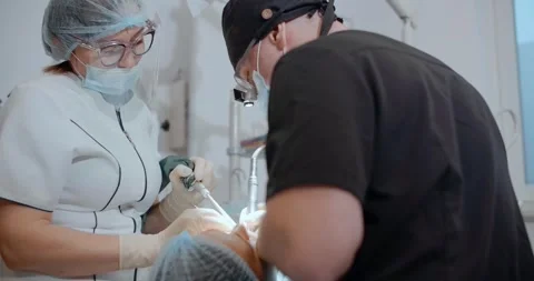 The dental surgeon does the surgery with assistant in stomatological clinic Stock Footage 270754292