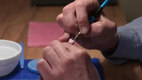 Dental technician applies ceramic material to the crown of a dental implant 動画素材 169936268