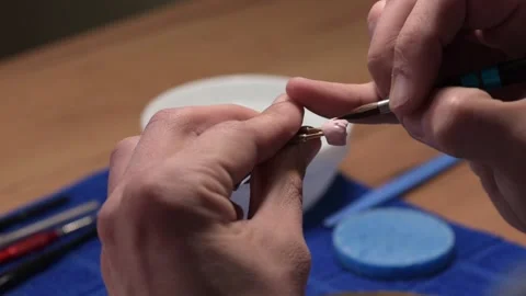 Dental technician applies ceramic material to the crown of a dental implant 動画素材 169936330