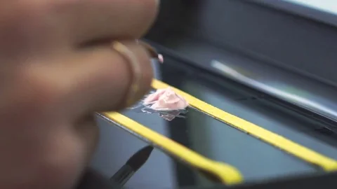 Dental technician applying ceramics glaze to a cast made with CNC dental machine Stock Footage