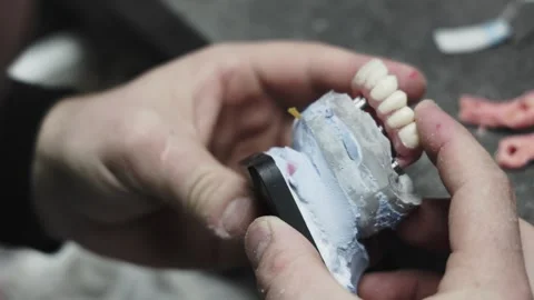 A dental technician checks a denture on a model Stock Footage 292510391