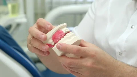 Dental technician holding plaster cast of jaws while making denture in lab Video stock 205871807