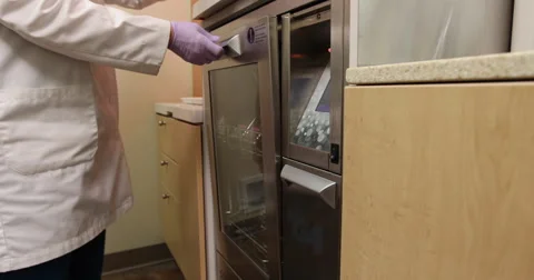 Dental Technician Loading Container in Washer Stock Footage 57754909