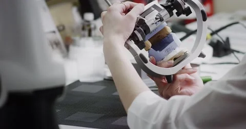 A dental technician makes a denture on a mock-up of the jaw. Stock Footage 163898997