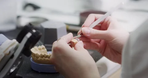 A dental technician makes a denture on a mock-up of the jaw. Stock Footage 163900804