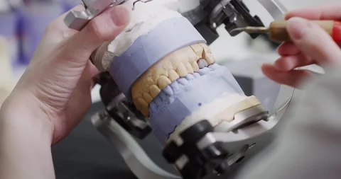 A dental technician makes a denture on a mock-up of the jaw. Stock Footage 163902407