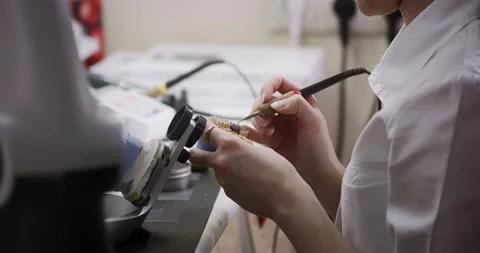A dental technician makes a denture on a mock-up of the jaw. Stock Footage 163904638