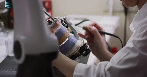 A dental technician makes a denture on a mock-up of the jaw. Stock Footage 163908677