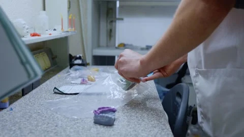 Dental technician packing plaster casts of teeth Видео 336659089