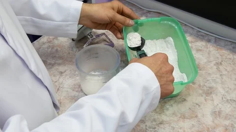 The dental Technician prepares the solution for the mixing of plaster Stock Footage 91975615