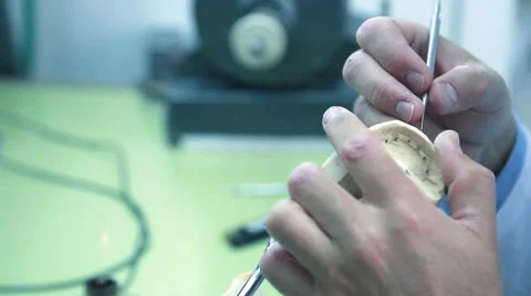 Dental technician removes excess wax from denture with a scalpel Stock Footage 66952853