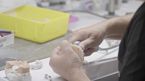 Dental Technician Shaping Denture Model in Laboratory Stock Footage 329813059