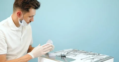 Dental technician working with a model of teeth and dental braces Stock Footage 147892881
