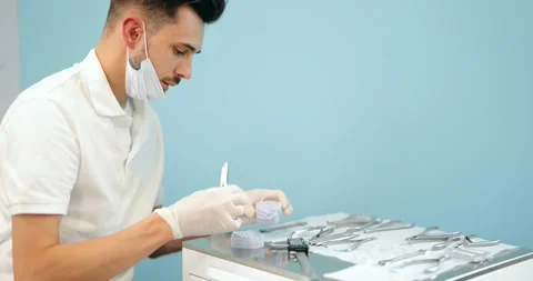 Dental technician working with a model of teeth and dental braces Stock Footage 147892955