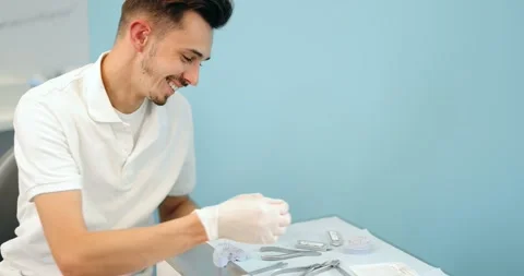 Dental technician working with a model of teeth and dental braces Stock Footage 147893236