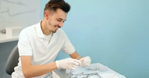 Dental technician working with a model of teeth and dental braces Stock Footage 147893273