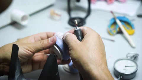 Dental technician works in his workshop and makes artificial teeth Stock Footage 207785855