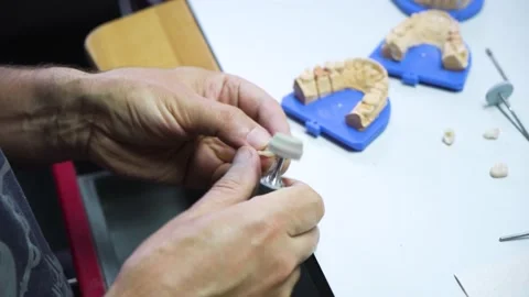 Dental technician works in his workshop and makes artificial teeth Stock Footage 208882425