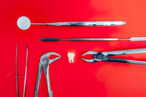 Dental tools and tooth model on red background Foto stock