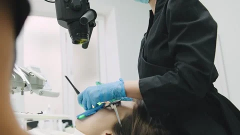 A dental worker uses a microscope to examine a patients teeth in a dental clinic 스톡 동영상 329316935