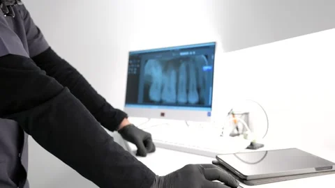 Dentist analyzing dental x ray on computer in modern clinic Stock Footage 306061419
