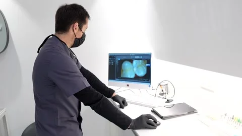 Dentist analyzing teeth x ray and intraoral scan images on computer Stock Footage 306061228