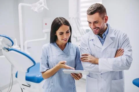 Dentist and assistant looking at digital tablet screen Stock Photos