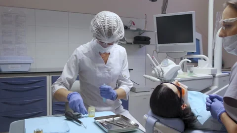 Dentist And Assistant Preparing For Surgery, White Coats And Masks Stock Footage 138061624