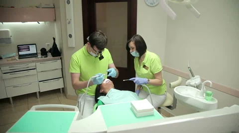 Dentist and assistant treating the patient teeth Stock Footage 63313639