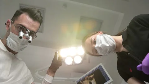 Dentist and assistant work with a patient, first-person view Stock Footage 163972879
