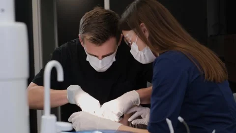 A dentist and his assistant during dental treatment using modern treatment Vidéo 243633765