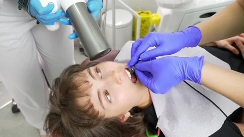 Dentist and his assistant scan patient's teeth Stock Footage 237698245