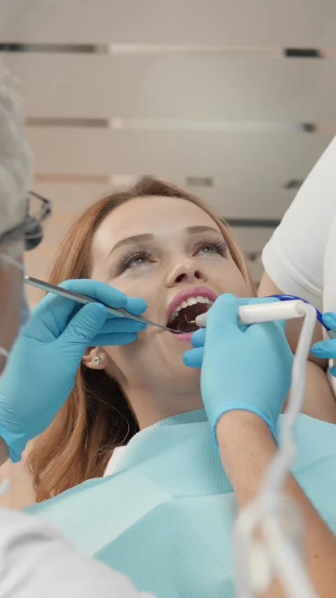 The dentist and his assistant work harmoniously in the dental chair, providing Stock Footage 270212574