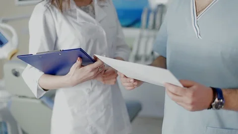 Dentist and his assistent having a professional discussion about diagnoses of Stock Footage 104353082
