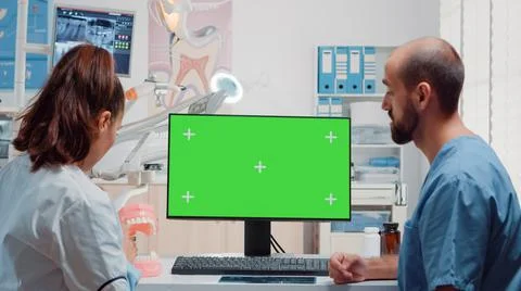 Dentist and man nurse analyzing green screen on computer Stock Photos