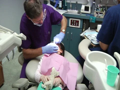 Dentist And Nurse Work With Young Girl Stock Footage 1098799