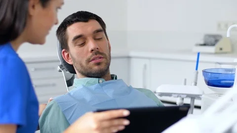 Dentist and patient discussing dental treatment Stock Footage