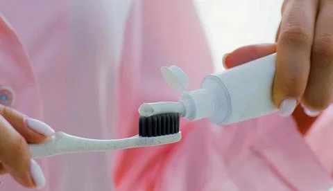 Dentist applying toothpaste on a toothbrush Stock Photos