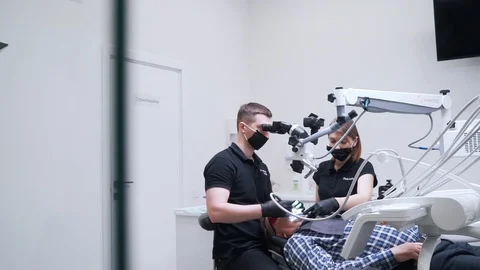 Dentist with an assistant working on a patient Stock Footage 112130894
