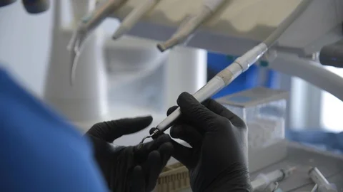 Dentist checking dental tool in clinic Stock Footage 89976750