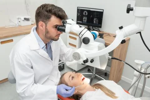 Dentist checking up patient teeth with microscope 스톡 사진
