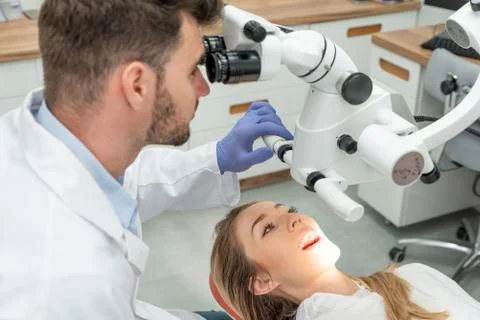 Dentist checking up patient teeth with microscope Stock Photos