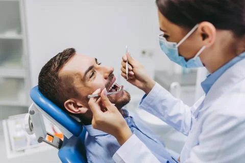 Dentist checking patient teeth Stock Photos