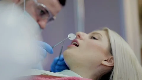 Dentist checking patient's teeth using special tool Stock Footage 104349613